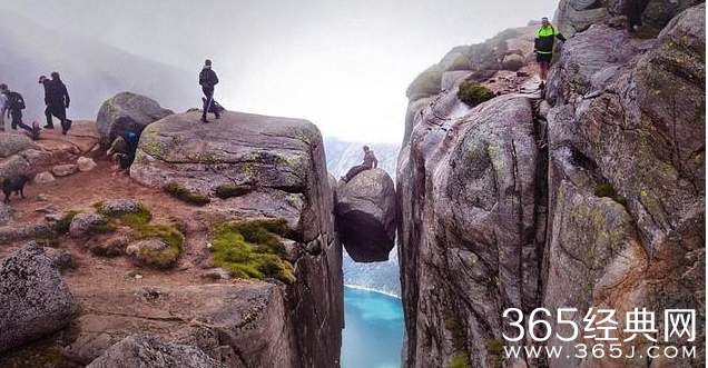 游客雨中登上挪威千米高悬石拍照