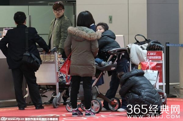 何洁携子现身机场 面容憔悴蹲地休息