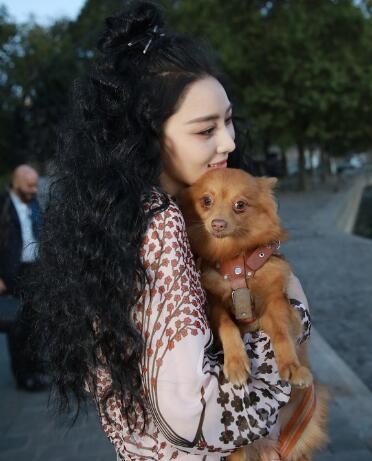 张馨予爆炸头亮相时装周 秀美腿街头抱小狗