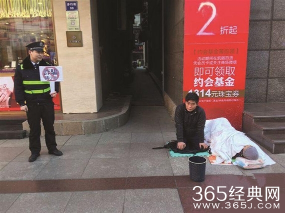 男子跪地乞讨 城管协管员一旁举牌