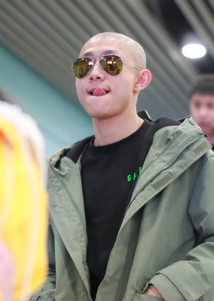 张一山光头造型现身机场 痞笑舔唇活似韦小宝本人