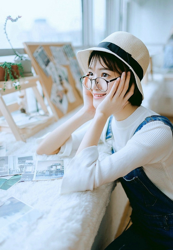 戴眼镜的短发女孩搂抱枕艺术照