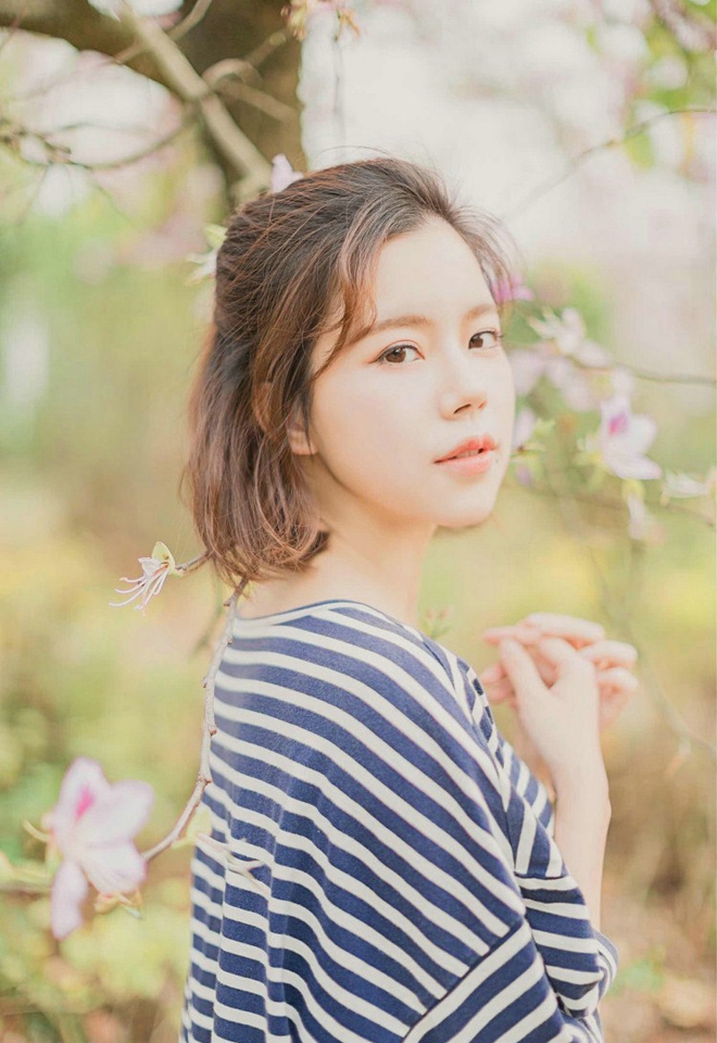 大眼睛休闲女紫荆花树下写真