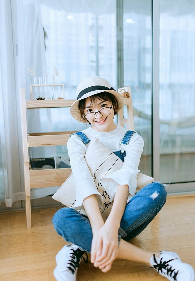 戴眼镜的短发女孩搂抱枕艺术照