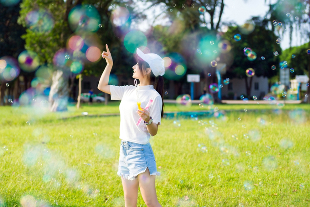 坐在草坪上吹泡泡清纯美女阳光气质写真照片