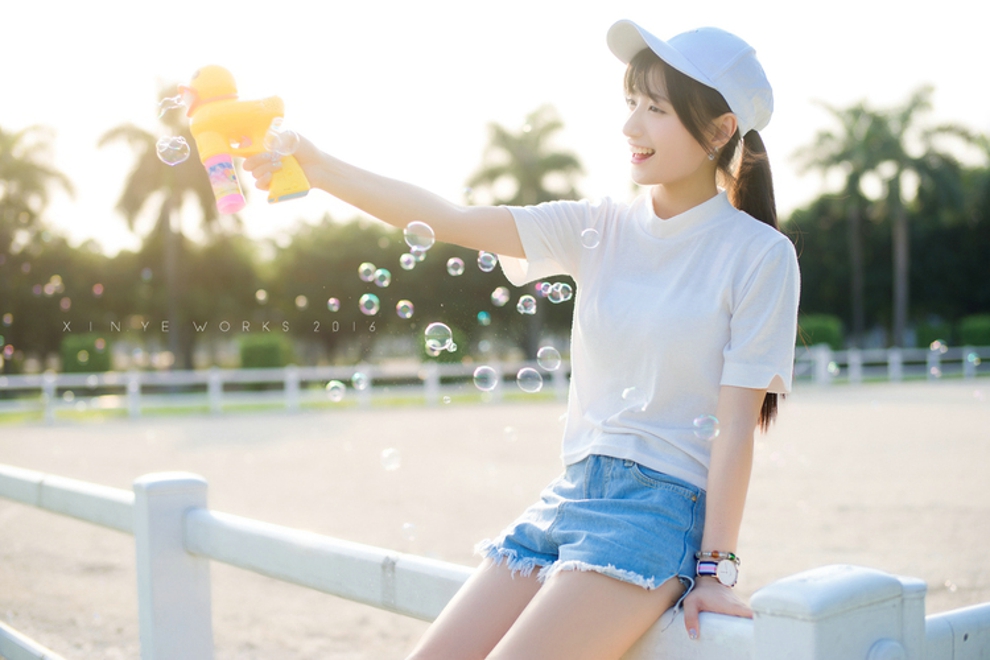 坐在草坪上吹泡泡清纯美女阳光气质写真照片