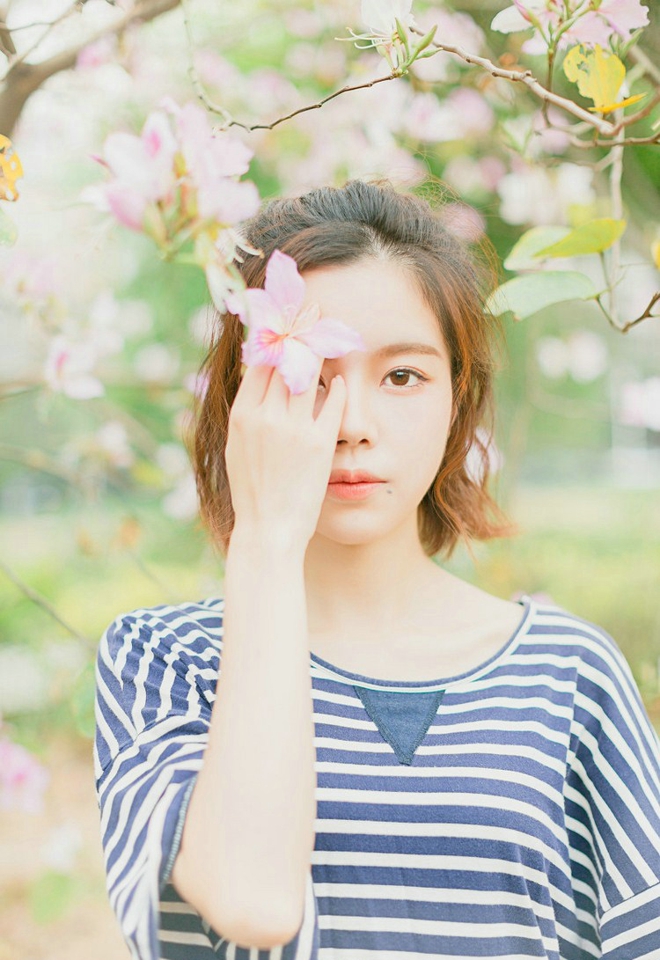 大眼睛休闲女紫荆花树下写真