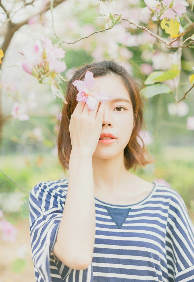 大眼睛休闲女紫荆花树下写真