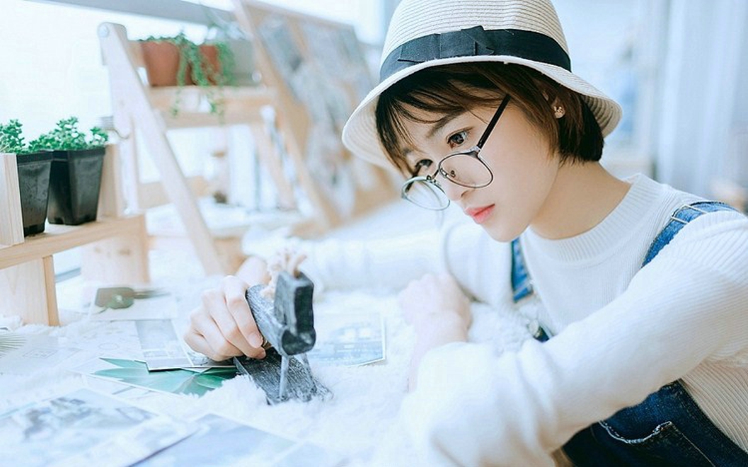 戴眼镜的短发女孩搂抱枕艺术照