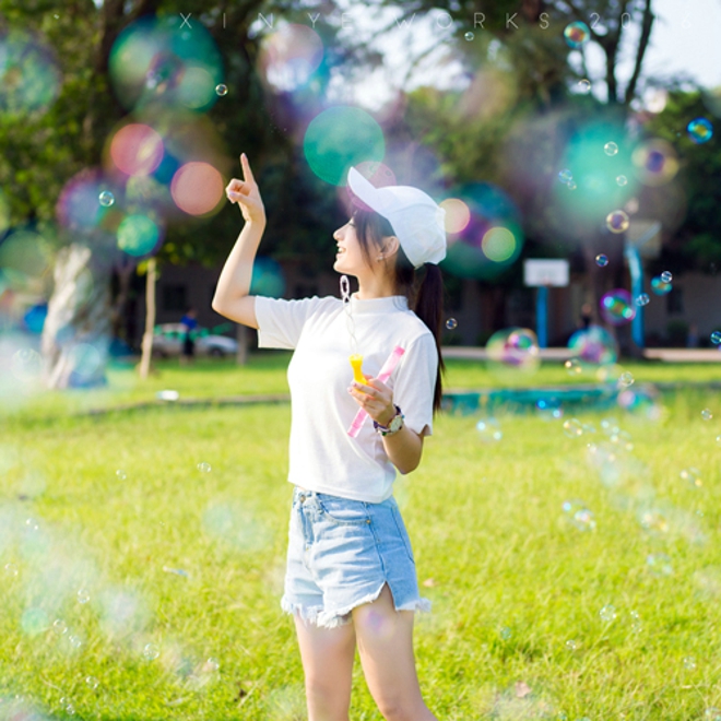 坐在草坪上吹泡泡清纯美女阳光气质写真照片