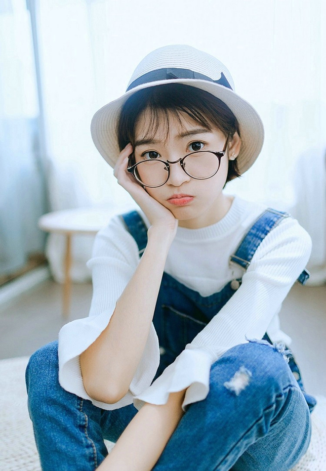 戴眼镜的短发女孩搂抱枕艺术照