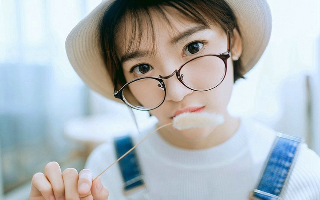 戴眼镜的短发女孩搂抱枕艺术照