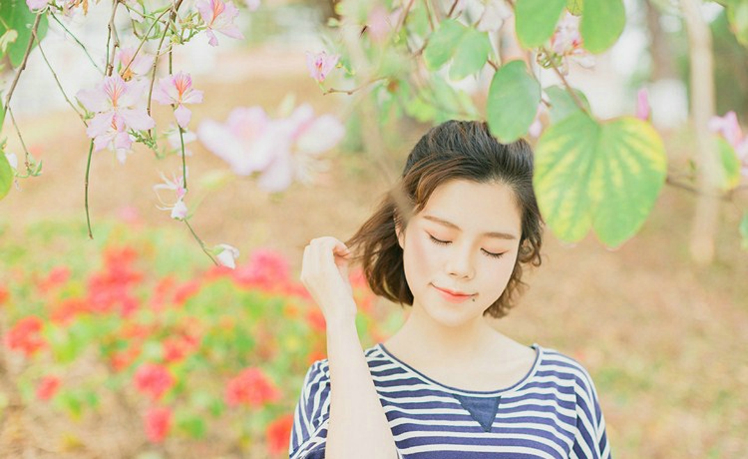 大眼睛休闲女紫荆花树下写真