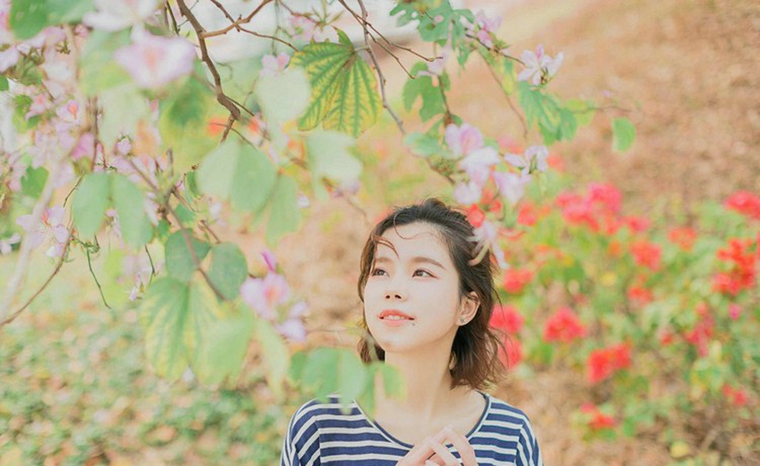 大眼睛休闲女紫荆花树下写真