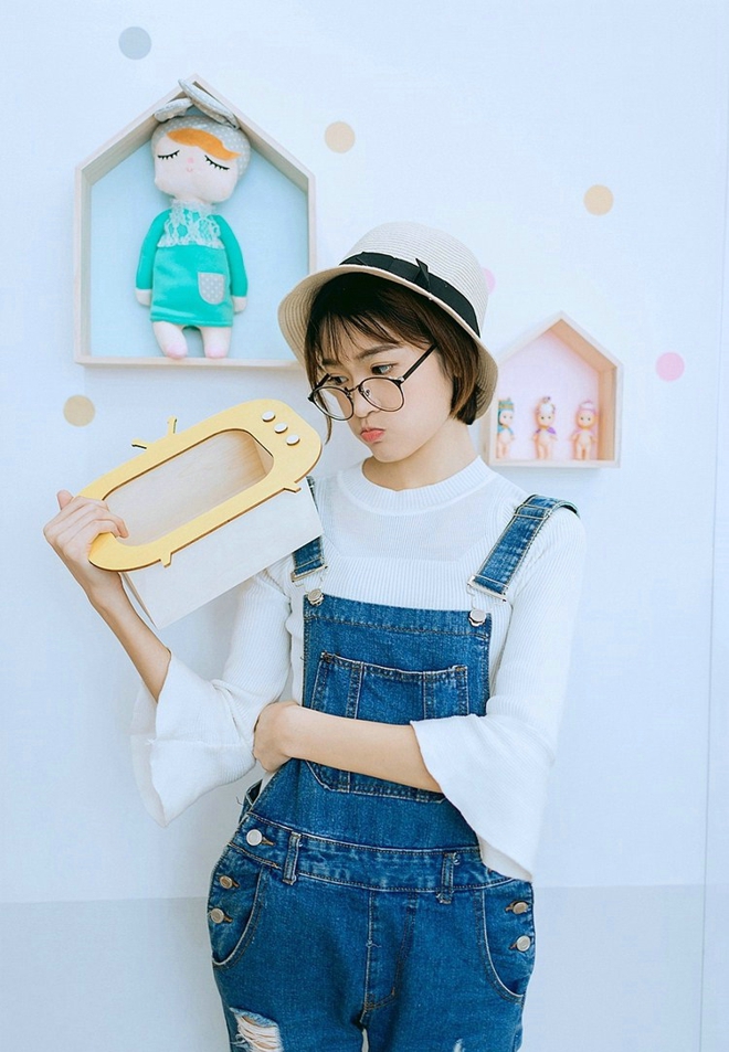 戴眼镜的短发女孩搂抱枕艺术照