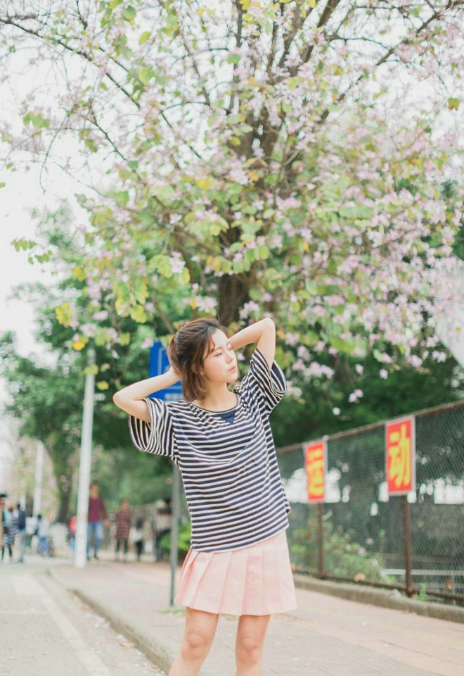 大眼睛休闲女紫荆花树下写真