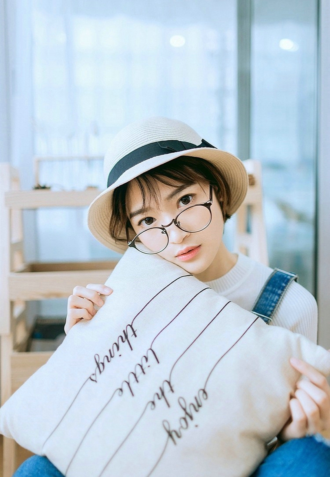 戴眼镜的短发女孩搂抱枕艺术照