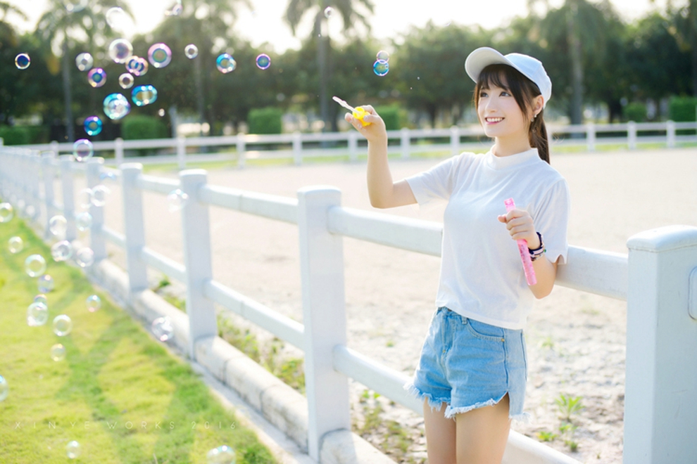 坐在草坪上吹泡泡清纯美女阳光气质写真照片