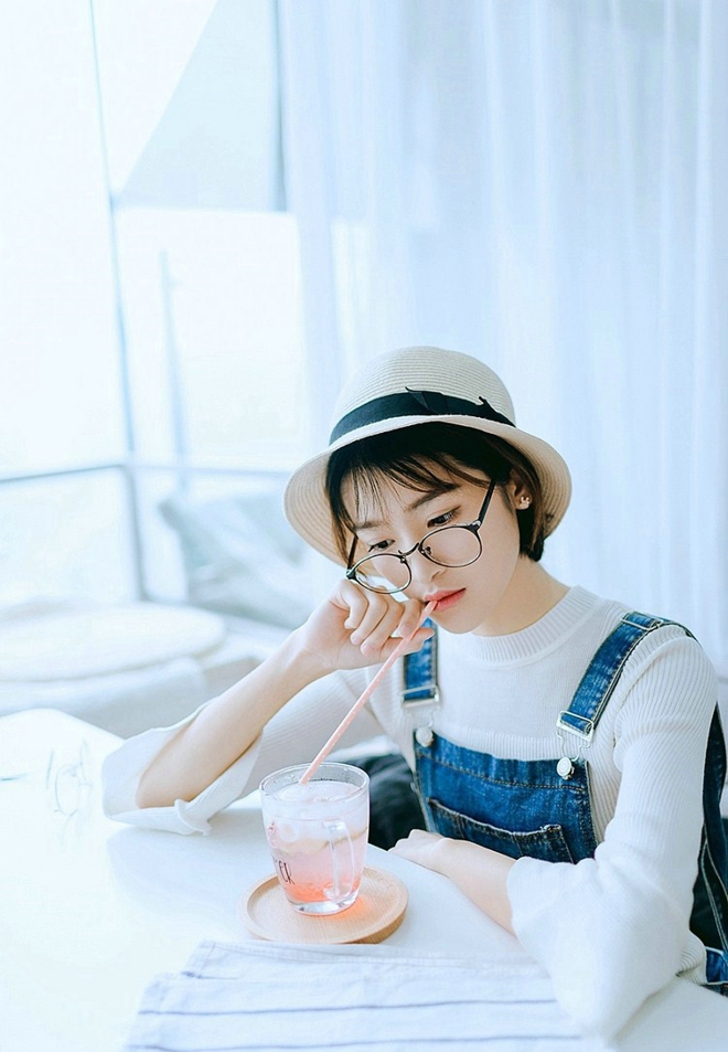 戴眼镜的短发女孩搂抱枕艺术照