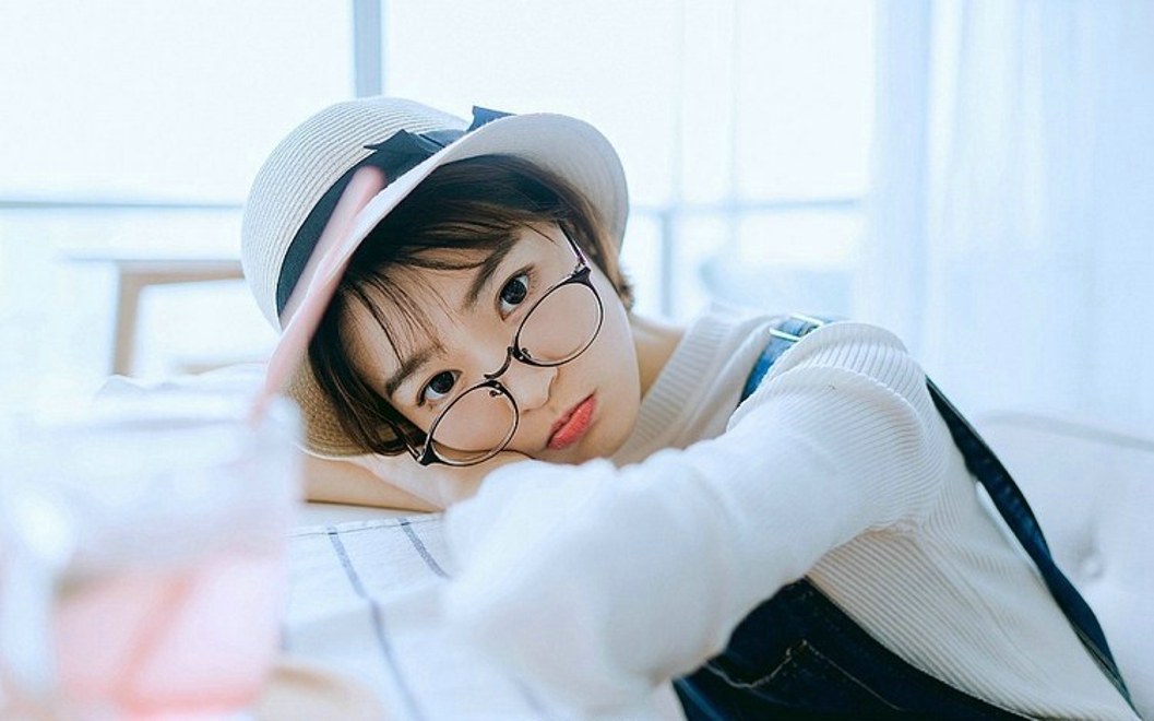 戴眼镜的短发女孩搂抱枕艺术照