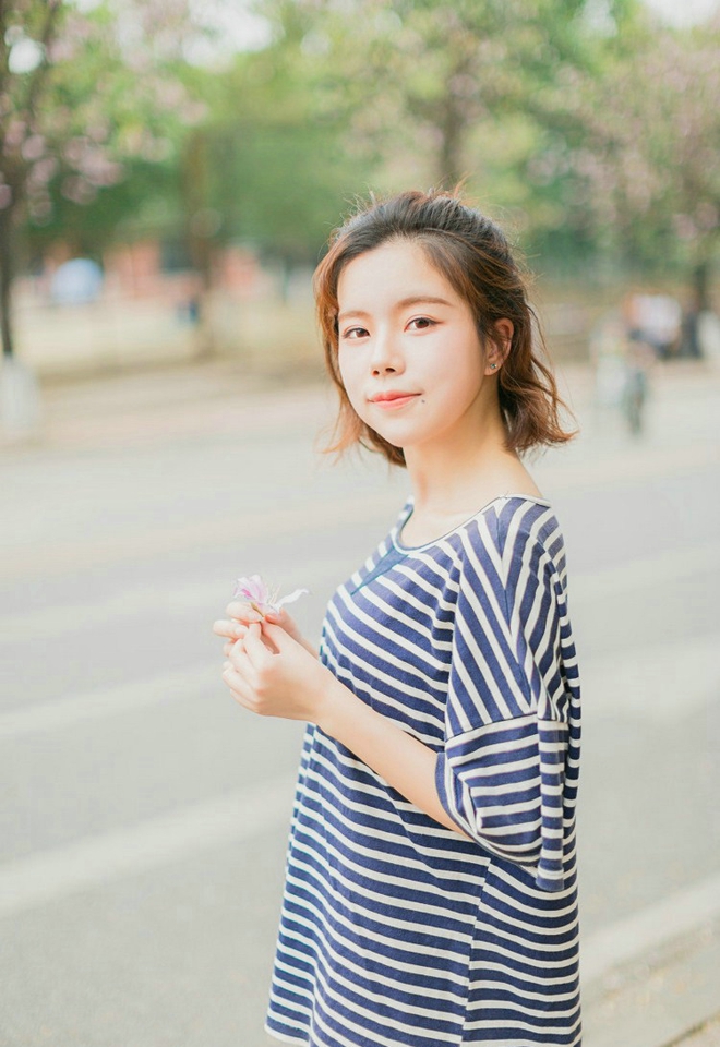 大眼睛休闲女紫荆花树下写真