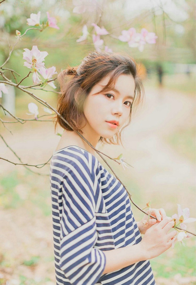 大眼睛休闲女紫荆花树下写真