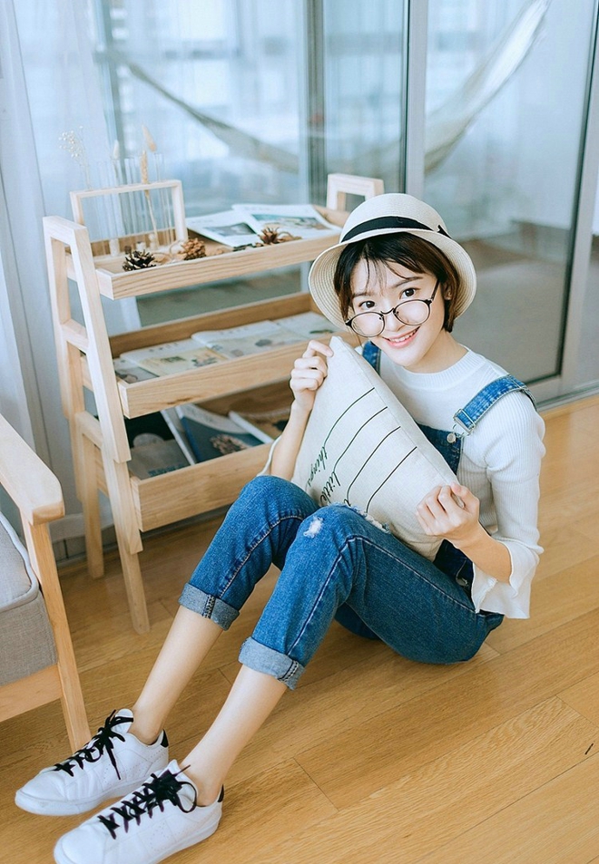 戴眼镜的短发女孩搂抱枕艺术照