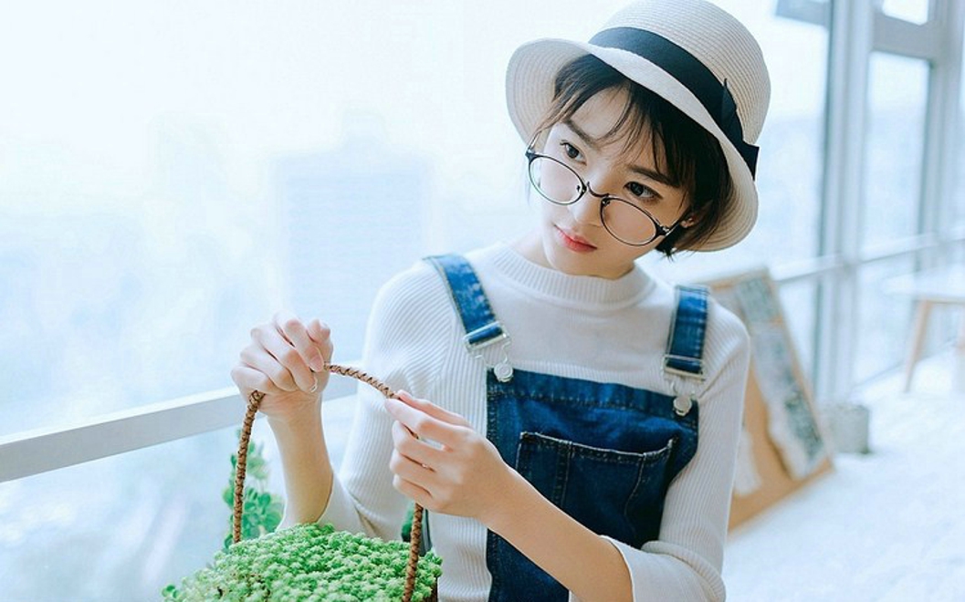 戴眼镜的短发女孩搂抱枕艺术照