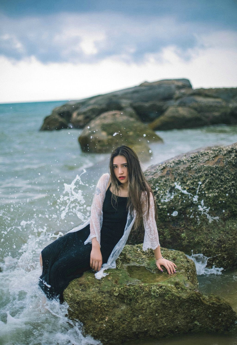 海岸礁石上的长发美女柔美秀发飘扬写真曝光