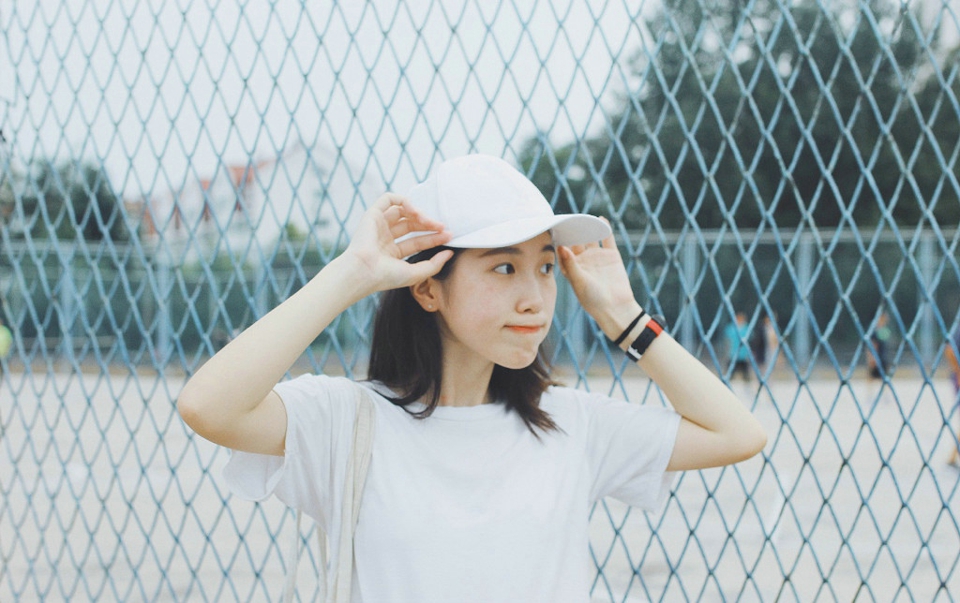 操场上的棒球帽休闲服饰明媚少女