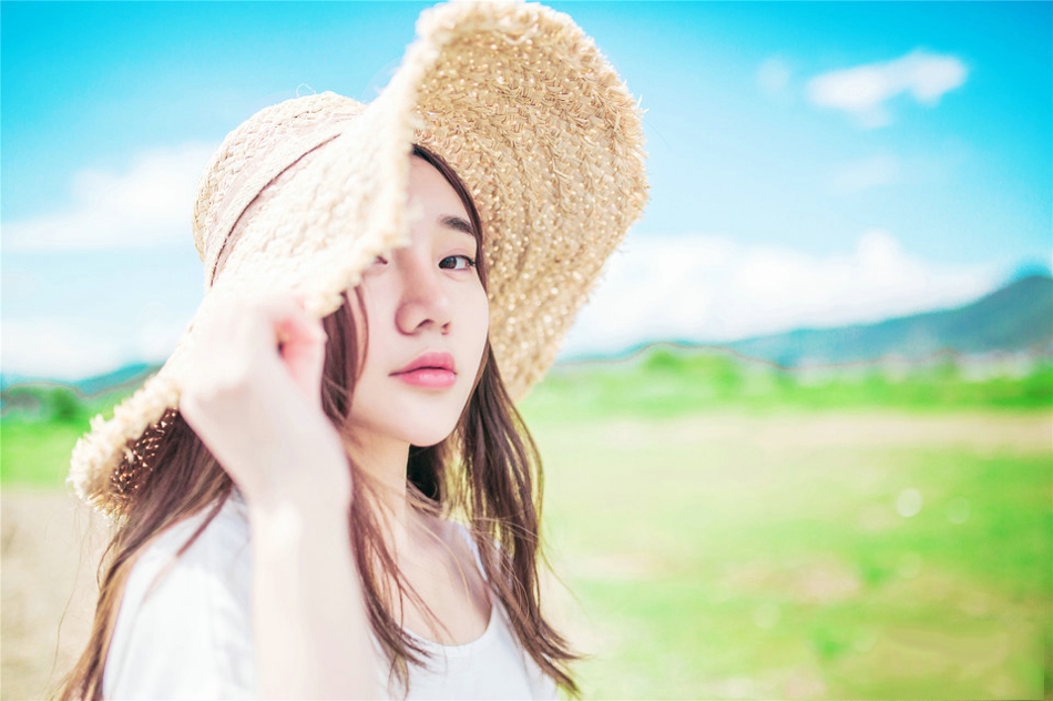 阳光下草帽美女海边风吹唯美写真