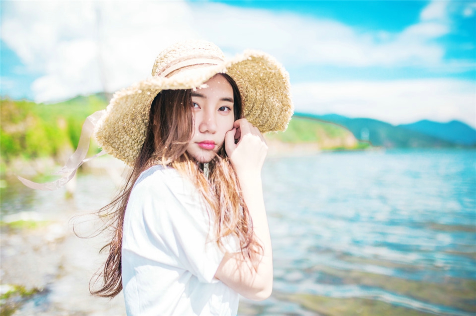 阳光下草帽美女海边风吹唯美写真